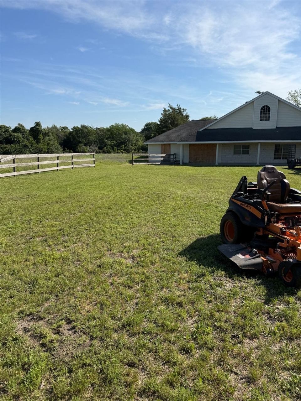 Zero-turn mower cutting a large country lawn